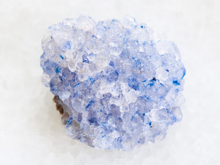 macro shooting of natural mineral rock specimen - raw celestine stone on white marble background