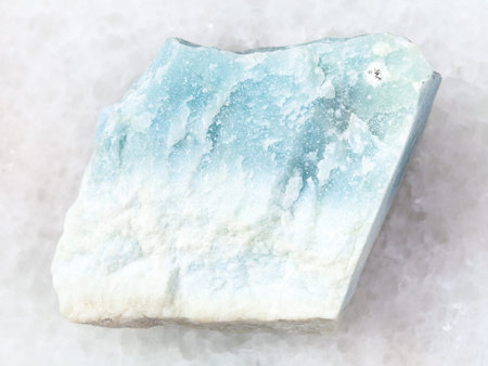 macro shooting of natural mineral rock specimen - rough blue Violane stone on white marble...