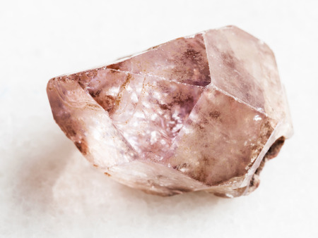 macro shooting of natural mineral rock specimen - raw crystal of amethyst gemstone on white marble background from Yakutia, Russiaの写真素材