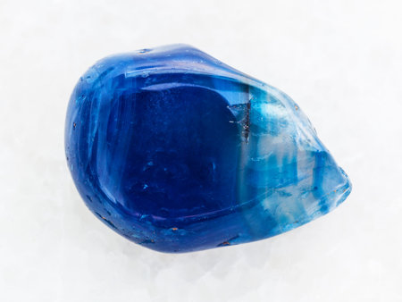 macro shooting of natural mineral rock specimen - polished blue toned agate gemstone on white marble...