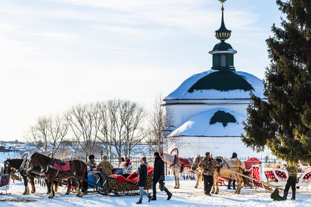 SUZDAL, RUSSIA - MARCH 9, 2018: people on horse sledges near Church of St Paraskeva or Pyatnitskaya Church in Suzdal town in sunny winter day winterのeditorial素材
