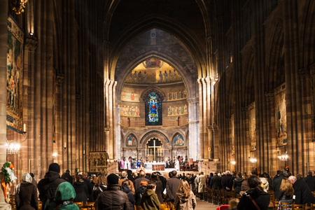 STRASBOURG, FRANCE - DECEMBER 11, 2011: people on night church service in The Cathedral of Notre Dame of Strasbourg city (Strassburger Muenster) during Christmas festive season.のeditorial素材