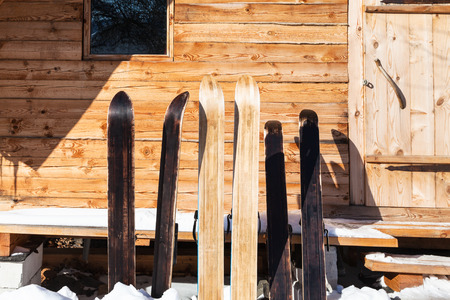 wide forest skis in front of wooden cottage in sunny winter day in russian village in Smolensk region of Russiaの写真素材