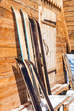 wide hunting skis near wall of wooden cottage in winter in russian in village in Smolensk region of Russiaの写真素材
