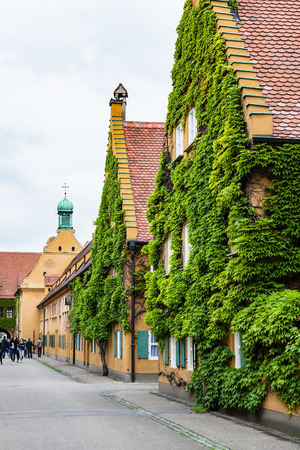 AUGSBURG, GERMANY - MAY 20, 2018: visitors near St Mark's church on Herrengasse street in Fuggerei housing in Augsburg town. Augsburg is a city in Swabia, Bavaria, it is third oldest city in Germanyのeditorial素材
