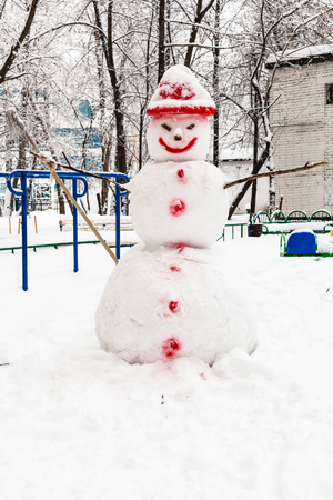 snowman at public urban yard in residential district of Moscow city in overcast winter dayの写真素材