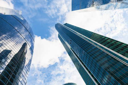 tall skyscrapers under blue sky with white clouds in business district of Moscow city in autumn