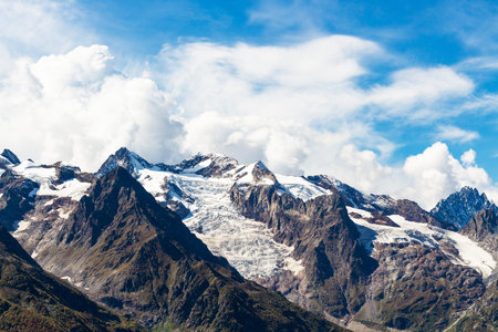 travel to North Caucasus region region - snow-covered mountain tops near Dombay resort village in...
