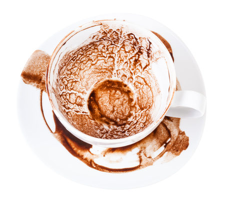 divination on carob drink grounds - above view of white porcelain cup on saucer with pattern of dried carob sediments isolated on white backgroundの写真素材