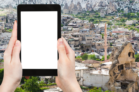 travel concept - tourist photographs of skyline of Goreme town in Cappadocia in spring in Turkey on smartphone with empty cutout screen with blank place for advertisingの写真素材
