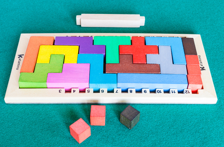 MOSCOW, RUSSIA - APRIL 3, 2019: wooden frame and blocks of Katamino puzzle game on green baize table. Katamino is version of pentomino puzzle designed by Andre Perriolat and published by Gigamic Gamesのeditorial素材