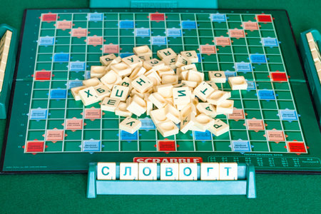 MOSCOW, RUSSIA - APRIL 3, 2019: pile of letter tiles on board of russian edition of Scrabble game . Scrabble is a word game, it was designed by Alfred Mosher Butts and first published in 1938のeditorial素材