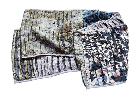 Folded scarf stitched from carved silk and cotton fabric isolated on white