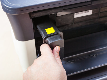 installing new toner cartridge in laser multi function device on table in office