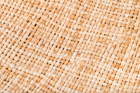textile background - weaving of summer straw hat from natural raffia fibers close up