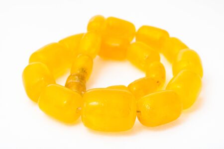 vintage coiled necklace from yellow melted amber on white paper backgroundの写真素材