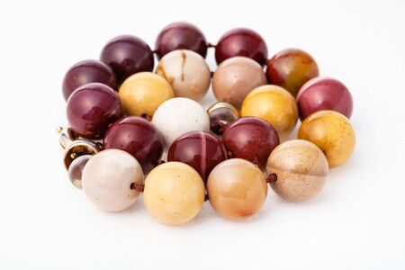 spiral necklace from polished natural australian mookaite jasper gemsones on white paper backgroundの写真素材