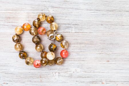 top view of tangled faceted agate necklace on gray wooden board with copyspaceの写真素材