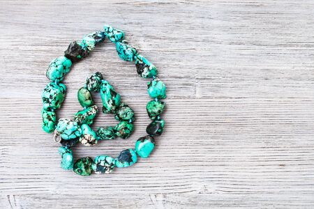 top view of dyed howlite (turquoise imitation) necklace on gray wooden board with copyspaceの写真素材