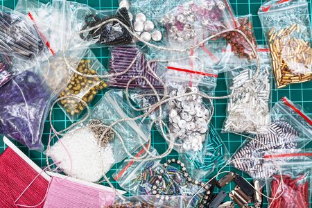 needlecraft background - top view of various items, beads, bugles, spangles, threads, gimps for embroidery close upの写真素材