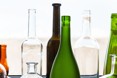 various empty bottles near home window on sunny spring day on background