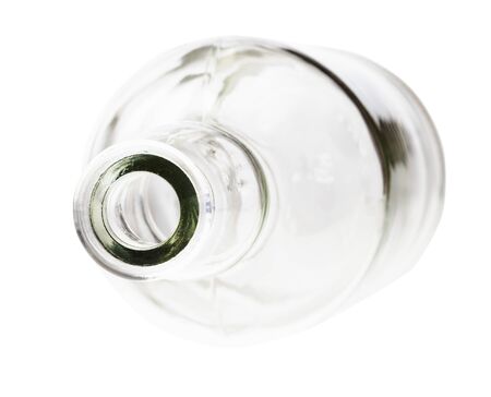 overturned empty clear brandy bottle isolated on white backgroundの写真素材