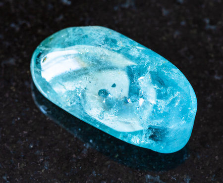 closeup of sample of natural mineral from geological collection - tumbled Aquamarine (blue Beryl)...