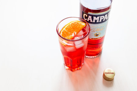 MOSCOW, RUSSIA - JUNE 4, 2020: cap, glass with cocktail and bottle of Campari bitter on table....