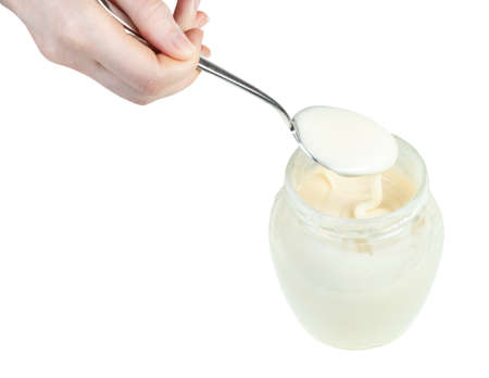 above view of natural organic white honey in steel spoon over glass jar with honey isolated on white backgroundの写真素材