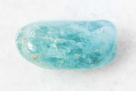 closeup of sample of natural mineral from geological collection - polished Aquamarine (blue Beryl) rock on white marble background from Brazilの写真素材