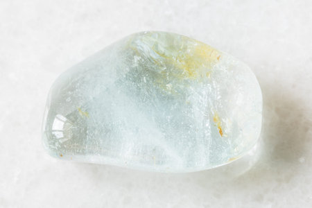 closeup of sample of natural mineral from geological collection - polished blue Topaz rock on white...