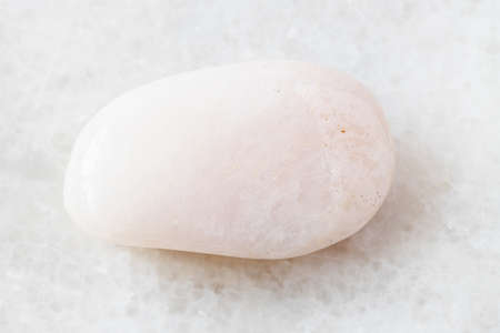 closeup of sample of natural mineral from geological collection - tumbled Petalite rock on white marble backgroundの写真素材