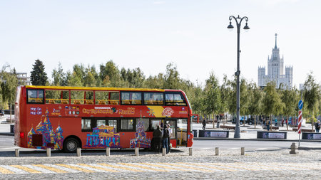 MOSCOW, RUSSIA - SEPTEMBER 27, 2020: tourist near a city sightseeing red bus on bus stop of Zaryadye...