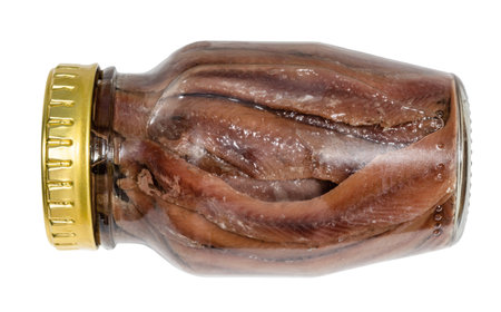 lying glass jar of canned anchovy fillets isolated on white backgroundの写真素材