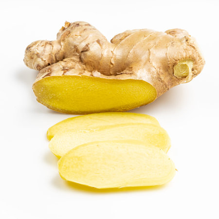 sliced fresh ginger root on gray plate close up