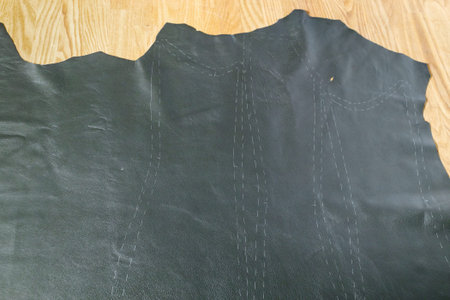 piece of leather with drawn pattern at wooden table