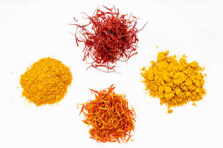 top view of saffron and its substitutes (crocus, turmeric, safflower, tagetes) on white plateの写真素材