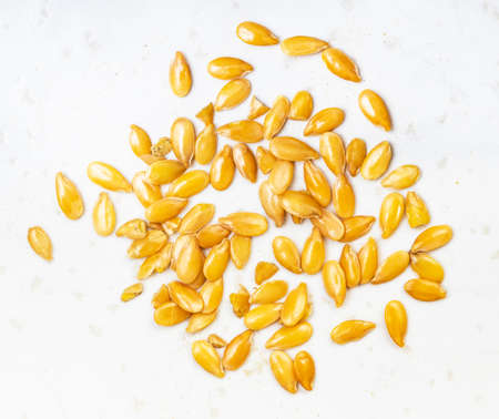 several golden flax seeds close up on gray ceramic plateの写真素材