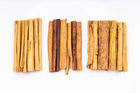 top view of various cinnamon sticks (alba premium ceylon, chinese cassia and continental ceylon cinnamon) on white plateの写真素材