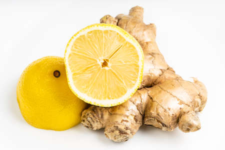 natural fresh whole ginger root and halved lemon fruit on gray plate close upの写真素材
