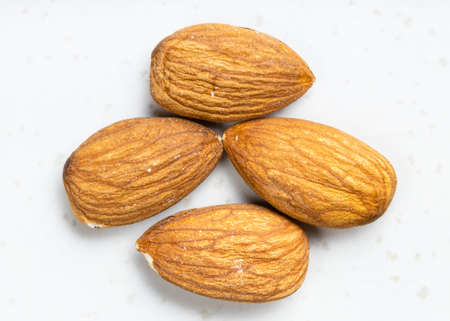 several raw almond seeds close up on gray ceramic plateの写真素材
