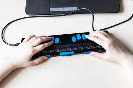 Moscow, Russia - June 5, 2021: hands on keys of Focus 40 Blue Braille Display. Freedom Scientific is the largest manufacturer of assistive technology products for blind and low vision peopleのeditorial素材