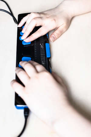 Moscow, Russia - June 5, 2021: hands on keys of Focus 40 Blue Braille Display close up. Freedom Scientific is the largest manufacturer of assistive technology products for blind and low vision peopleのeditorial素材