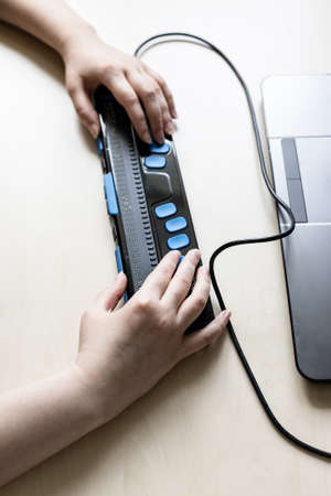 Moscow, Russia - June 5, 2021: hands touch Focus 40 Blue Braille Display. Freedom Scientific is the largest manufacturer of assistive technology products for blind and low vision peopleのeditorial素材