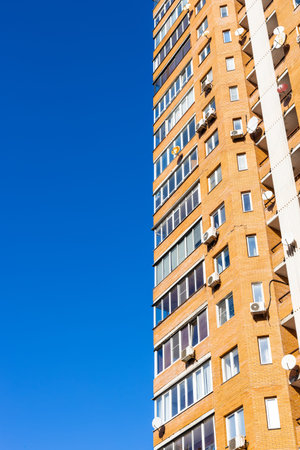 multi-storey brick apartment house and blue sky on sunny day