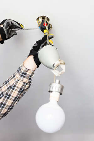 electrician removing fault ceiling lamp at homeの写真素材