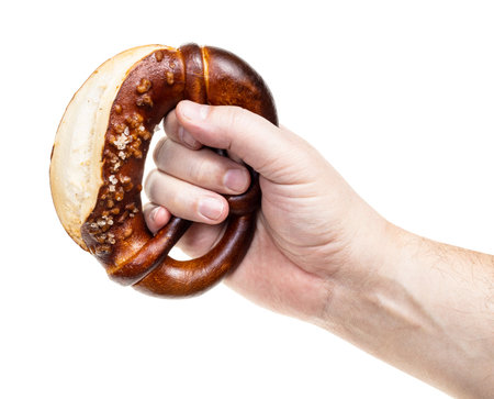 male hand holds bretzel with salt crystals isolated on white background