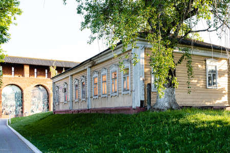 Kolomna, Russia - June 9, 2022: old wooden urban house near ancient citadel wall of Yamskaya tower of Kolomna Kremlin in Old Kolomna city on sunny summer eveningのeditorial素材
