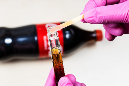 Moscow, Russia - January 12, 2023: measurement of pH level of Coca Cola Classic, the pink indicator shows acidity. Coca-Cola (Coke) is carbonated soft drink manufactured by Coca-Cola Companyのeditorial素材