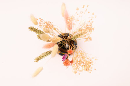 top view of bouquet of dried flowers and spikelets in vase on pink pastel backgroundの写真素材